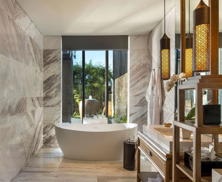 Luxuriöses Badezimmer mit freistehender Badewanne und Marmorwänden
