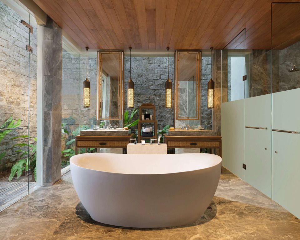 Elegantes Badezimmer mit freistehender Badewanne und Steindetails