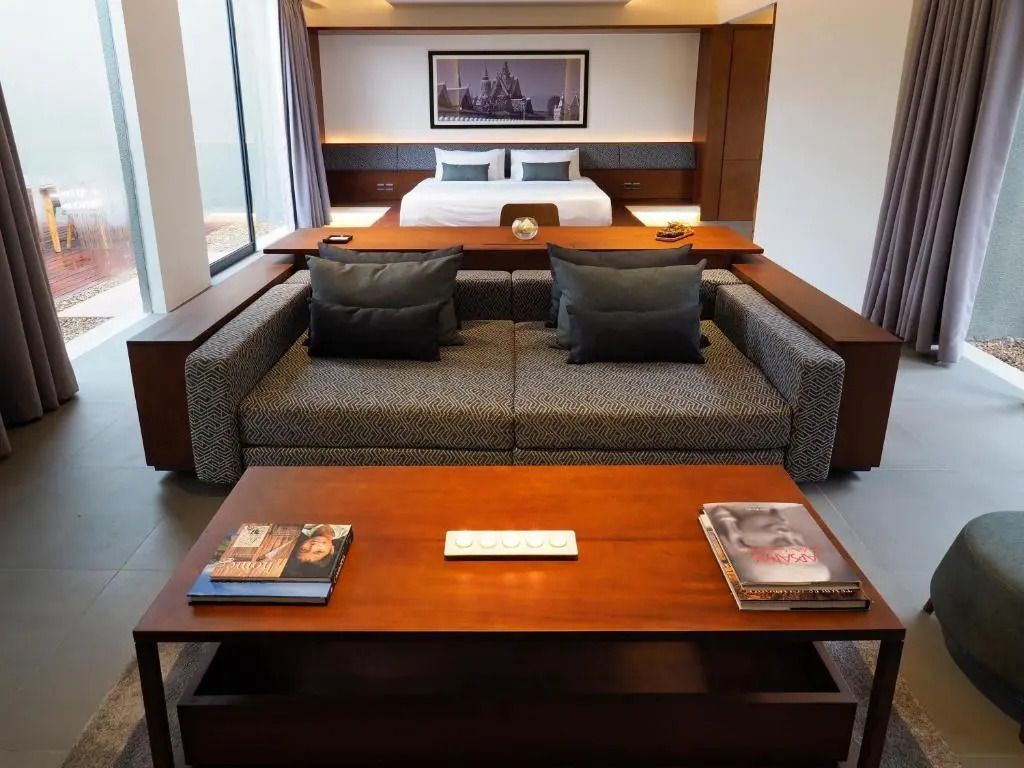 Doppelzimmer in Suite mit modernem Design, großem Bett und gemütlichem Sofa.