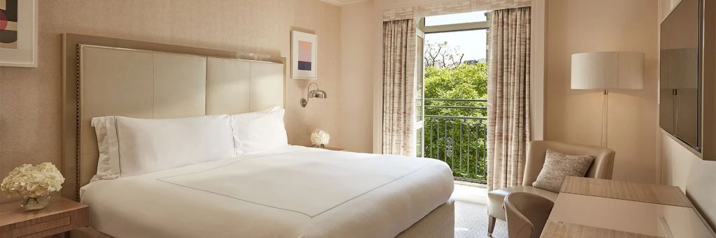 Hell beleuchtetes Doppelzimmer mit großem Bett und offenem Balkonzugang