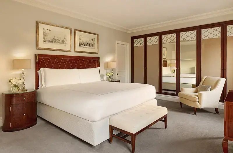 Elegantes Schlafzimmer mit großem Doppelbett und Kunstwerken an der Wand