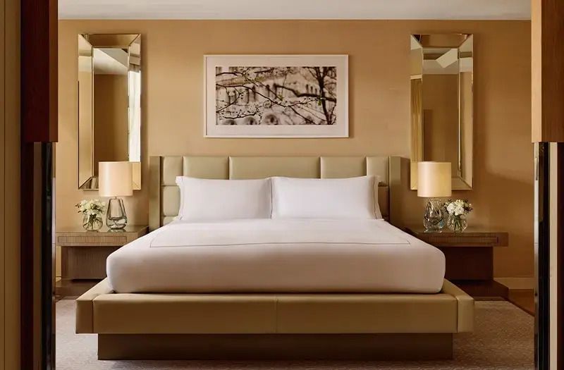 Elegante Suite mit Doppelbett und stilvollen Nachttischlampen.