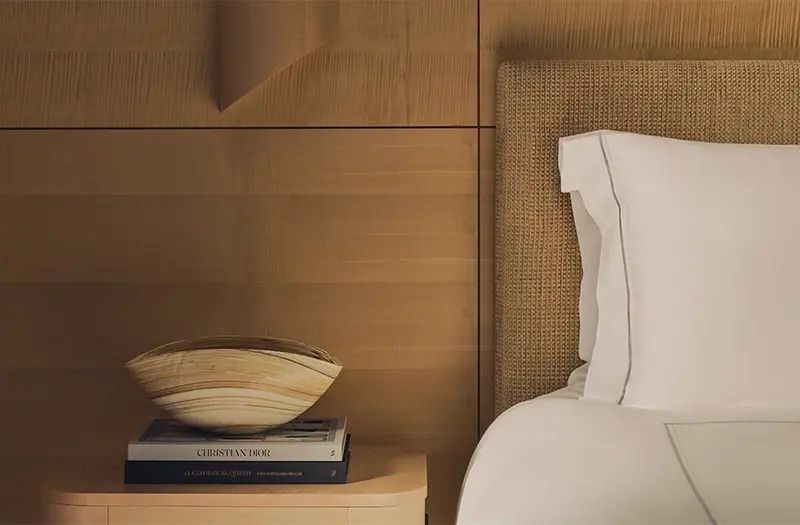 Nachttisch mit Designer-Schale und Büchern neben einem Bett
