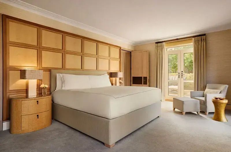 Elegantes Schlafzimmer mit großen Fenstern und komfortablem Bett.