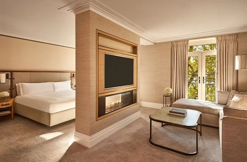 Luxuriöser Wohnbereich mit Kamin und großem Fernseher in der Deluxe Doppel Junior-Suite.