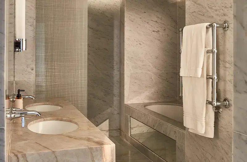 Hochwertiges Marmorbad mit Doppelwaschbecken und Badewanne in der Deluxe Junior-Suite.