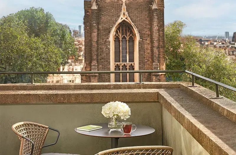Balkontisch mit Blumen und Blick auf gotische Architektur