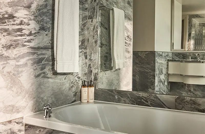 Luxuriöses Badezimmer mit Marmorverkleidung und Badewanne