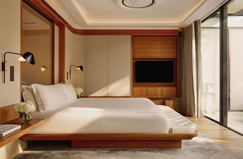Geräumiges Schlafzimmer mit Doppelbett und elegantem Design in Holz und neutralen Farben