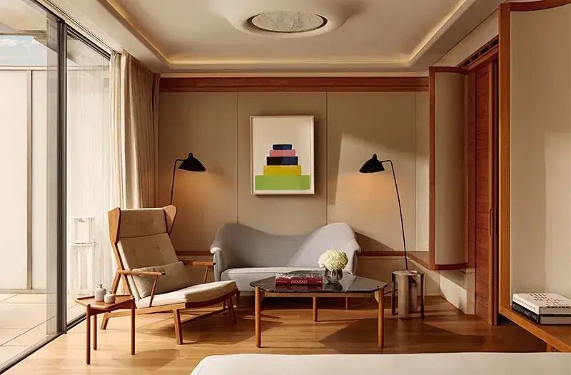 Gemütliche Sitzecke mit Designerstühlen und Kunstwerk an der Wand in der Suite