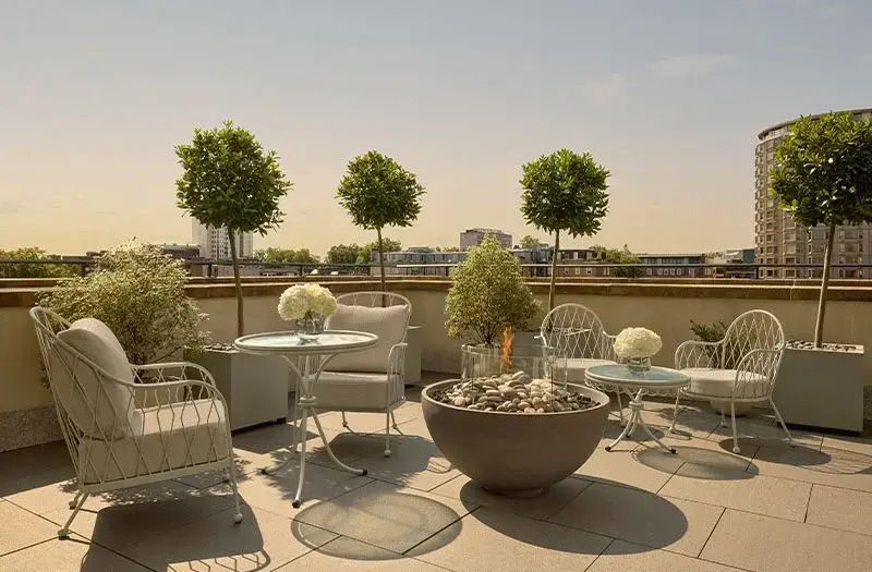 Sonnige Terrasse mit eleganten Gartenmöbeln und Pflanzen