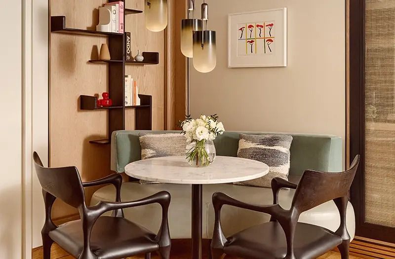 Runder Tisch mit Designerstühlen und Blumenstrauß in der Park Doppel Suite