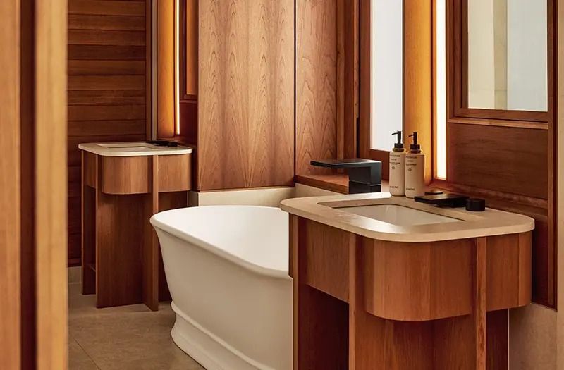 Modernes Badezimmer mit freistehender Badewanne und Holzverkleidung im Berkeley Hotel