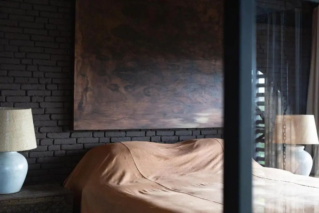 Gemütliches Schlafzimmer mit modernem Kunstwerk an der Wand