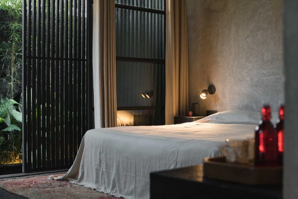 Schlafzimmer mit großem Bett, eleganten Vorhängen und natürlichem Licht