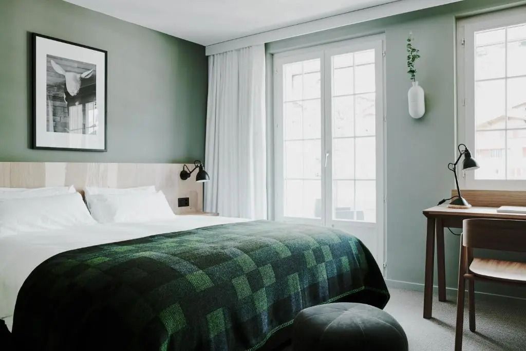 Helles Deluxe Doppelzimmer mit Doppelbett und großen Fenstern für viel Tageslicht