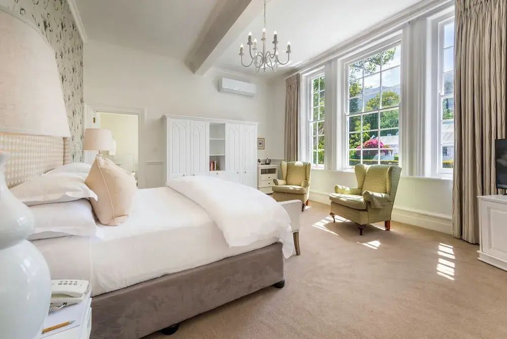 Großzügiges Schlafzimmer mit eleganten Sesseln und natürlichem Licht