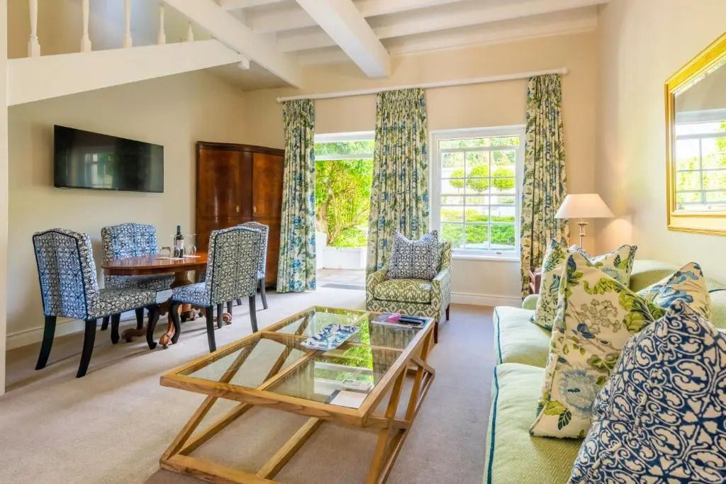 Wohnbereich der Suite mit Sofa, Tisch und Essbereich