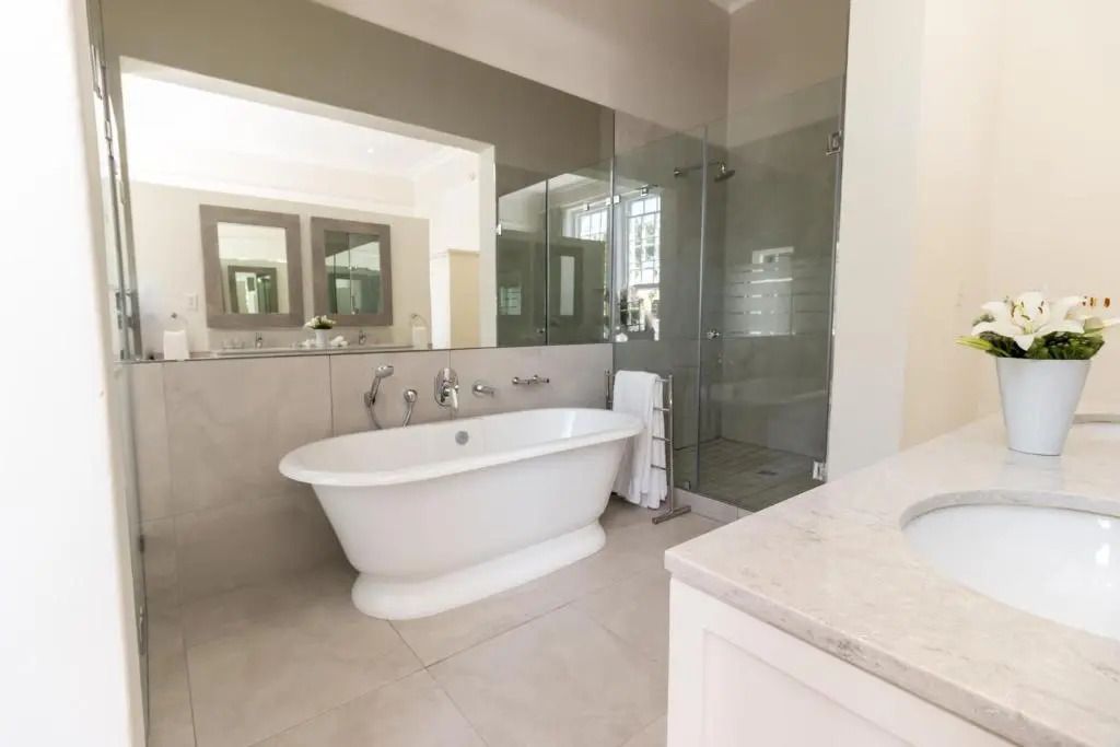 Elegantes Badezimmer mit freistehender Badewanne und großer Glasdusche