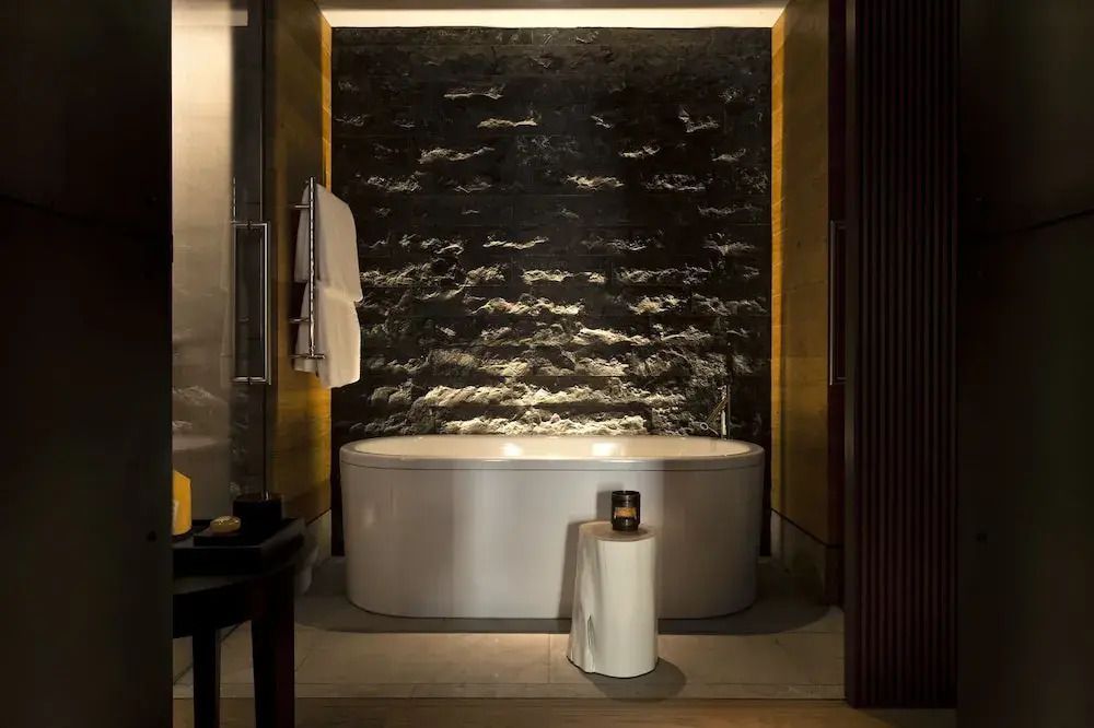 Luxuriöses Badezimmer mit eleganter Badewanne und dunkler Steinwand
