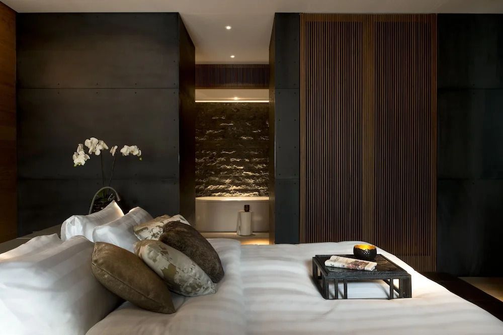 Luxuriöse Suite mit gemütlichen Kissen, eleganter Beleuchtung und offenem Badbereich