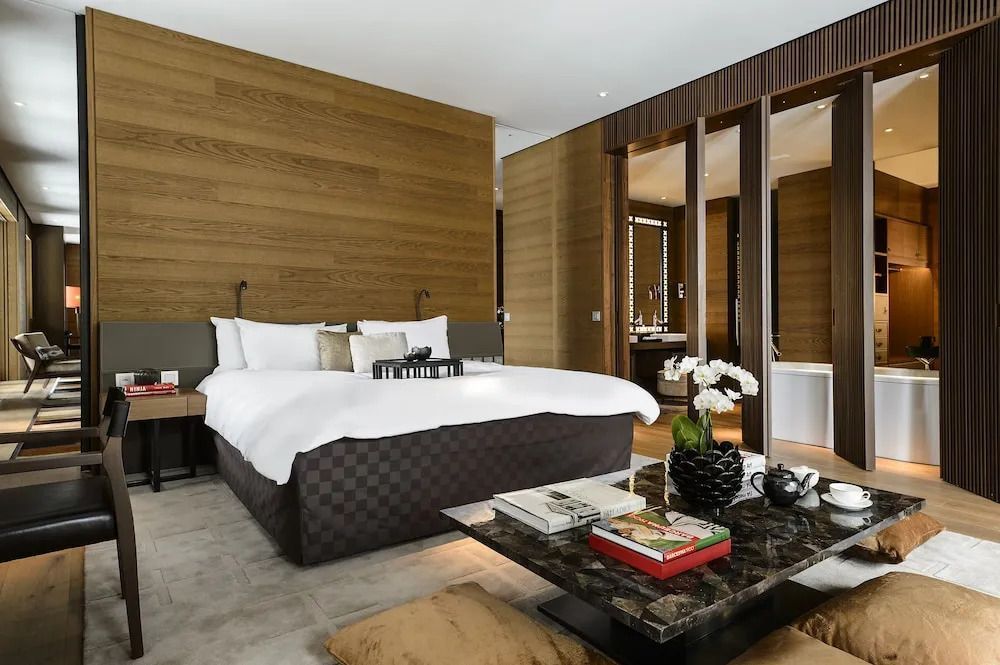 Moderne Suite mit Doppelbett, eleganten Holzakzenten und großem Fenster