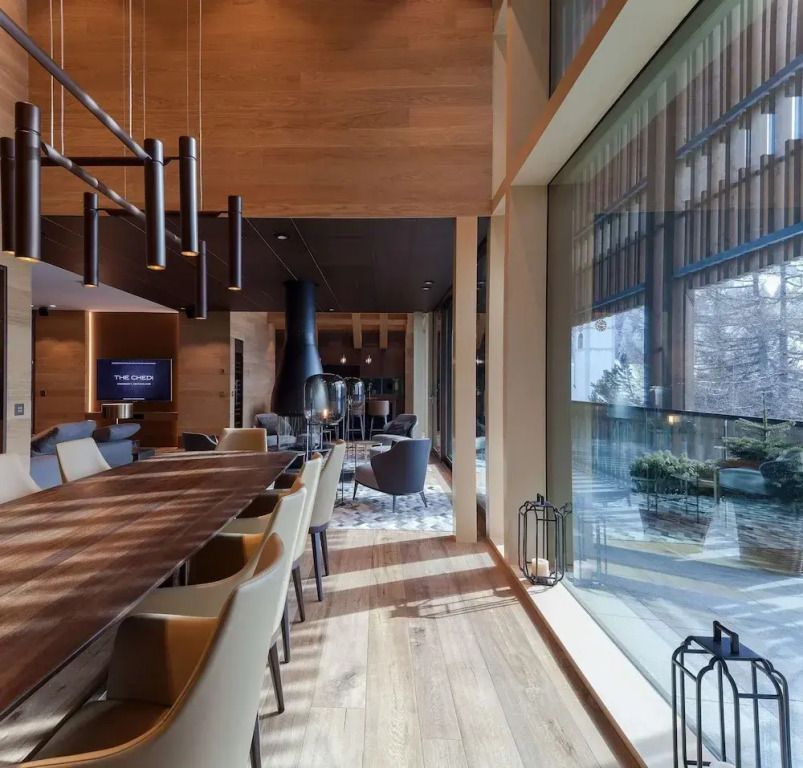 Elegantes Lounge-Ambiente mit modernem Dekor und großen Fenstern.