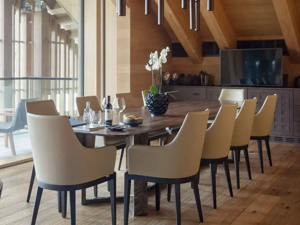 Elegantes Esszimmer mit langen Tisch und luxuriösen Stühlen.