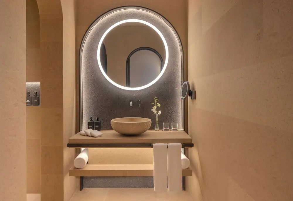 Elegantes Badezimmer der Suite mit beleuchtetem Spiegel und Waschbecken