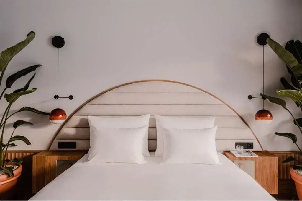 Doppelbett mit eleganter Kopfteilbeleuchtung in einer luxuriösen Suite
