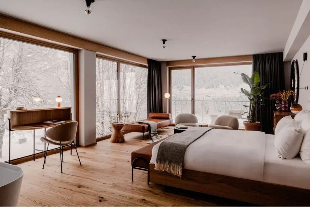 Großzügige Suite mit Balkon und Panoramablick auf verschneite Landschaft