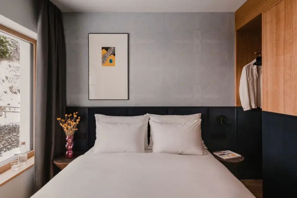 Elegantes Hotelzimmer mit Kunst an der Wand und gemütlichem Doppelbett