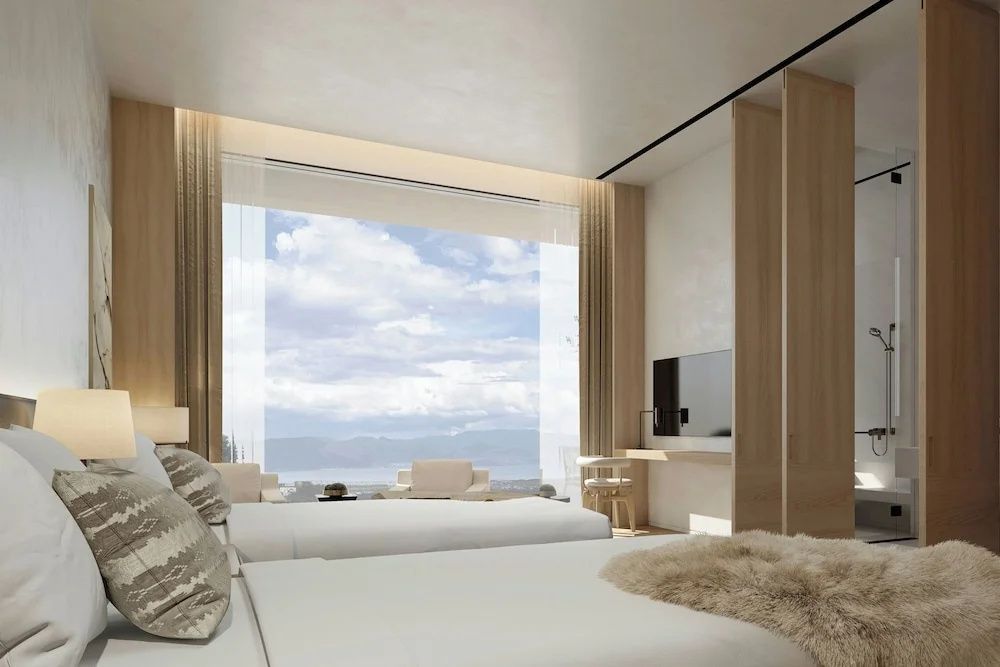 Helles Hotelzimmer mit großen Panoramafenstern und beeindruckendem Ausblick auf die Landschaft.