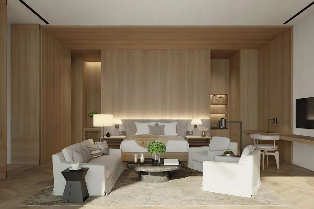 Eleganter Wohn und Schlafbereich einer Suite mit Holzverkleidung, modernem Sofa und bequemen Sesseln.