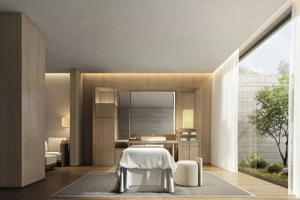 Luxuriöser Spa Behandlungsraum mit Massageliege, stilvollen Holzmöbeln und sanftem Licht.