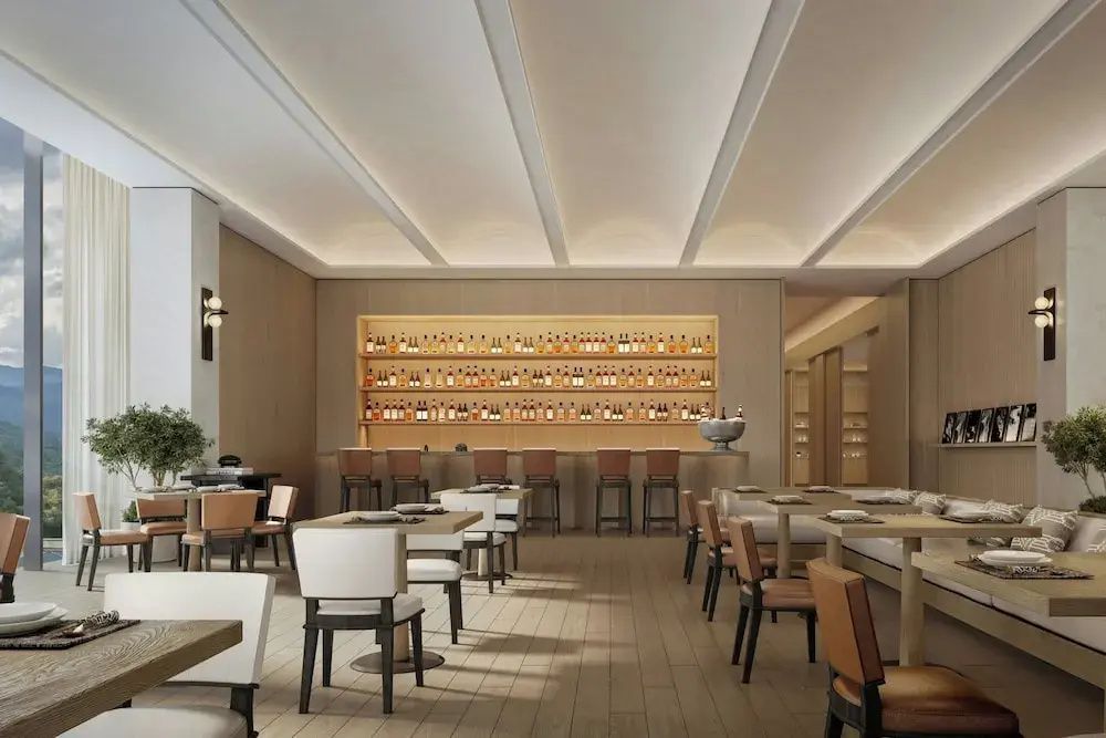 Stilvolle Hotelbar im The Dali EDITION mit beleuchtetem Regal, minimalistischen Holzstühlen und Tischen.