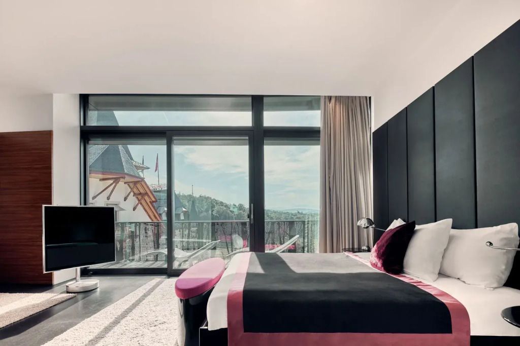 Luxuriöses Doppelzimmer mit großem Fenster und Ausblick auf den Balkon und die Umgebung