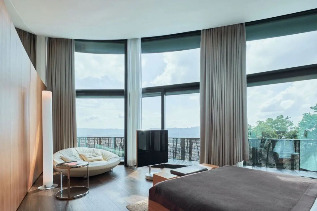 Große bodentiefe Fenster in der Suite mit komfortabler Sitzecke und eleganten Möbeln