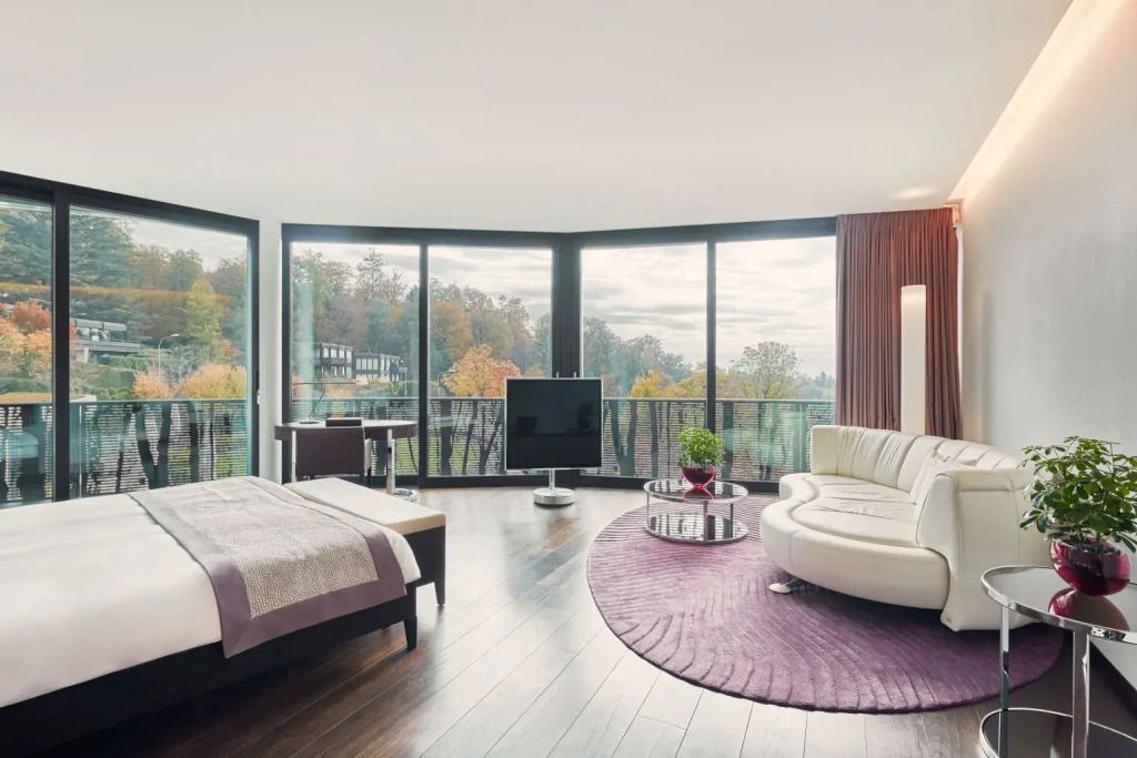 Modernes Zimmer mit elegantem Sofa und großem Fenster mit Blick auf die Natur