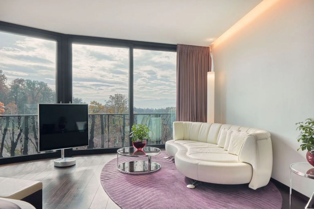 Gemütliche Sitzecke mit Designer-Sofa vor großen Fenstern