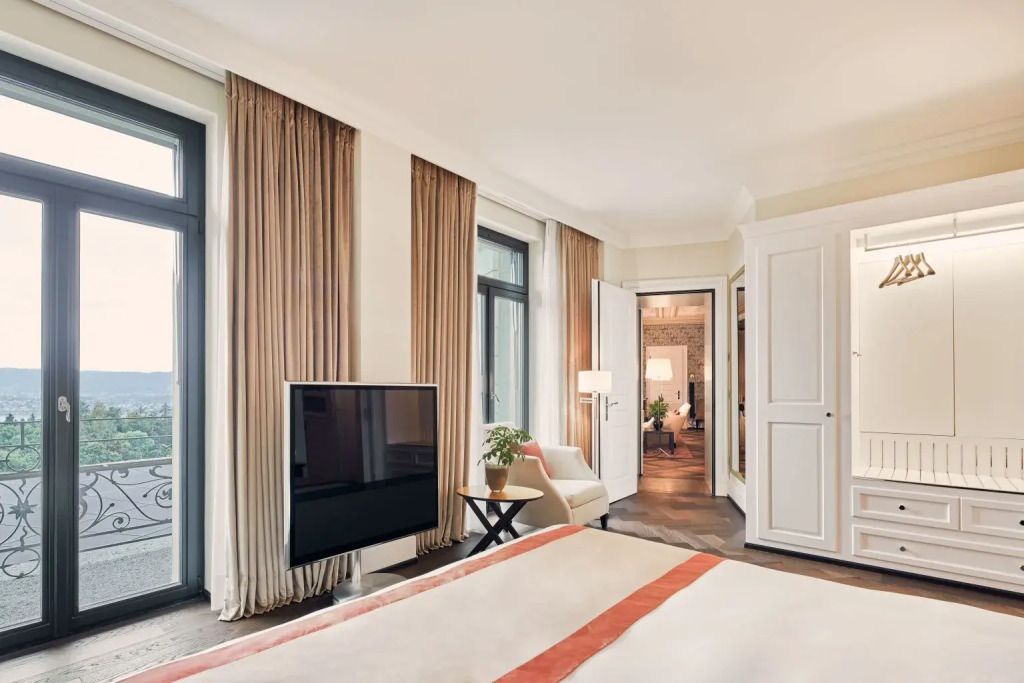 Helles Zimmer mit Fernseher und großen Fenstern zur Terrasse