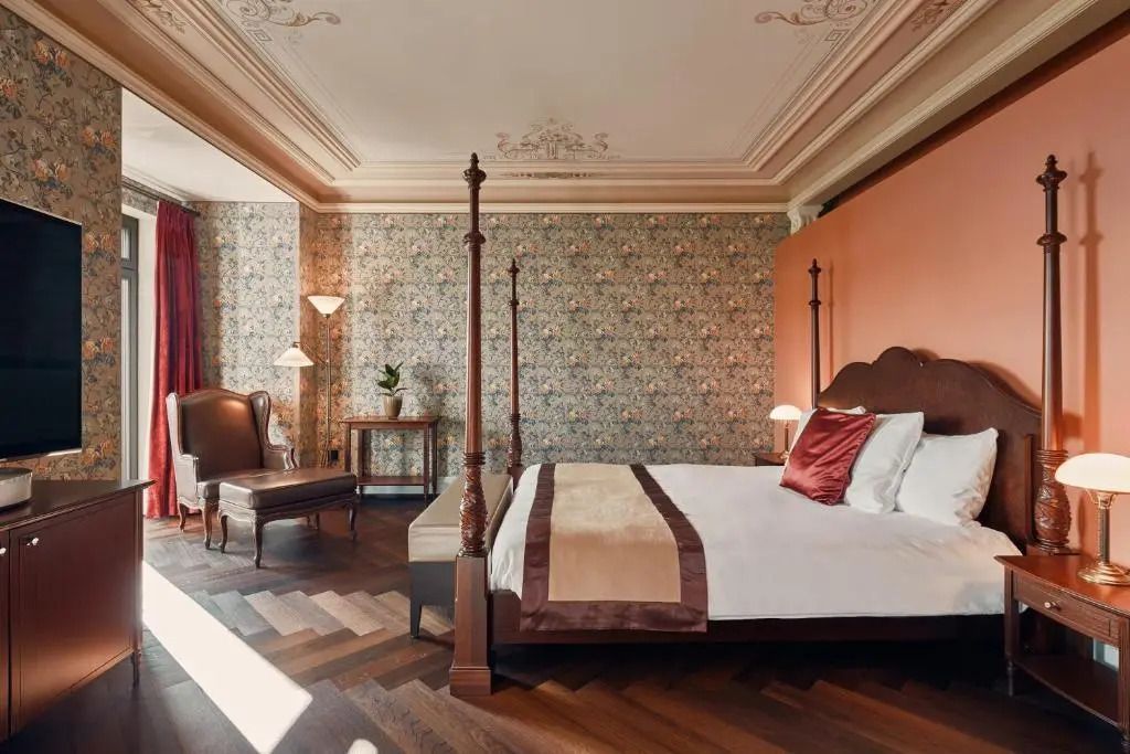 Elegantes Schlafzimmer mit Himmelbett und stilvoller Tapete im Dolder Grand.