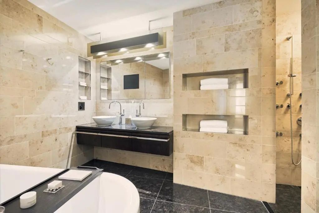 Modernes Badezimmer mit Doppelwaschbecken und Marmorfliesen im Dolder Grand.