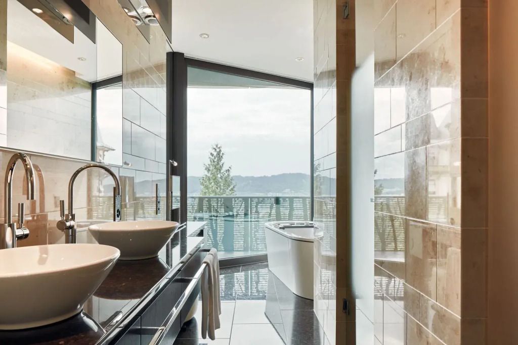 Badezimmer mit Badewanne und Fensterblick ins Grüne in der Golf Doppel Suite