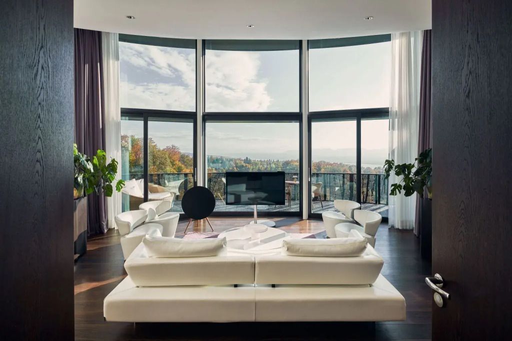 Helles Wohnzimmer der Golf Doppel Suite mit großen Fenstern und Balkonblick