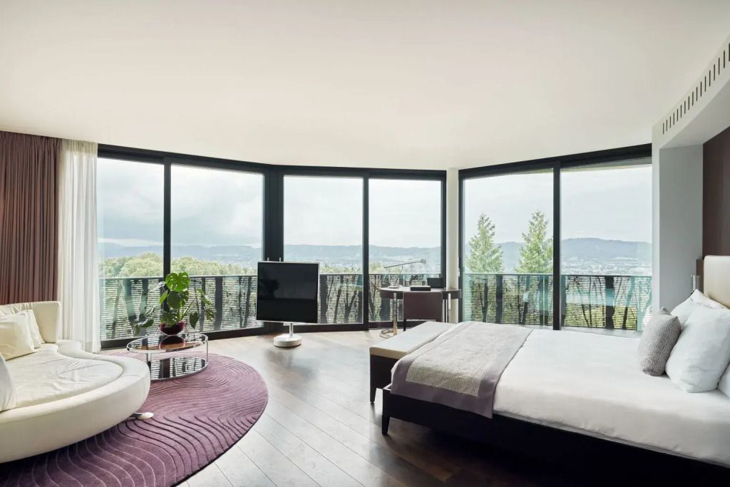 Junior-Suite mit Panoramafenstern und Bett mit herrlichem Blick