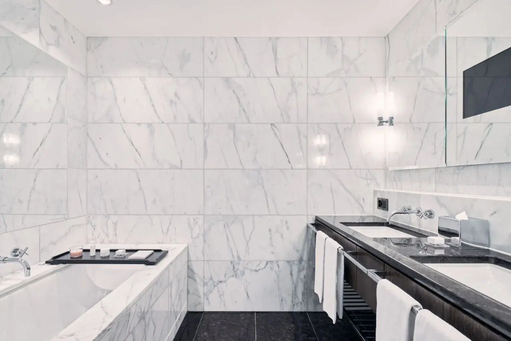 Luxuriöses Bad mit Marmorfliesen und versenkter Badewanne