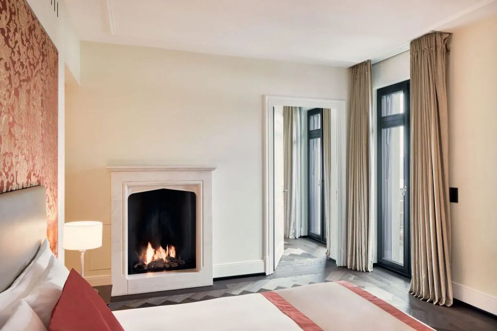 Gemütlicher Kamin in einer Grand Doppel Suite mit großen Fenstern