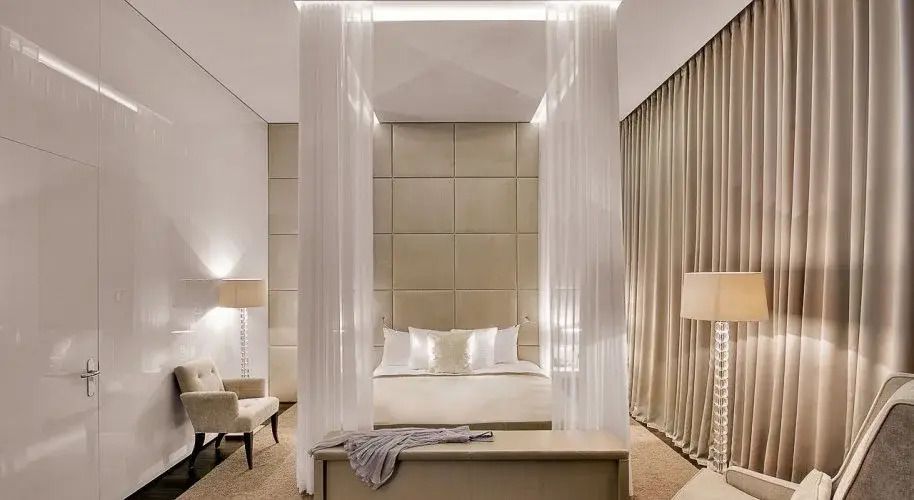 Luxuriöses Schlafzimmer mit Himmelbett und gedämpftem Licht in der Maestro Doppel Suite