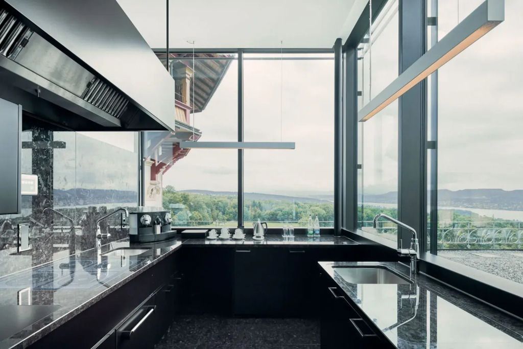 Moderne Küche mit Panoramablick und dunklen Arbeitsplatten in der Suite.